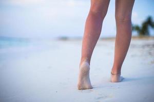 Nahaufnahme der männlichen Beine am weißen Sandstrand foto