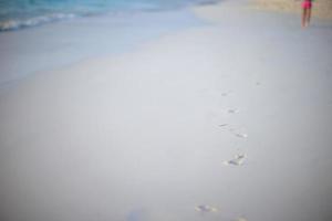 menschliche Fußabdrücke am weißen Sandstrand foto