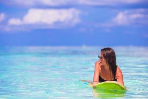 schöne Fitness-Surferin, die während der Sommerferien surft foto