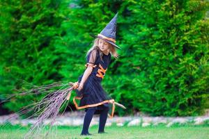 entzückendes kleines mädchen, das hexenkostüm an halloween am herbsttag trägt. Süßes oder Saures. foto