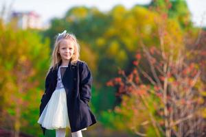 entzückendes kleines Mädchen draußen am schönen Herbsttag foto