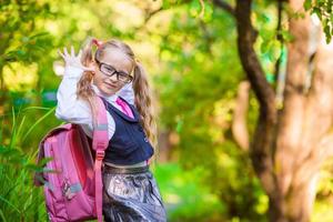 entzückender Schulmädchen-Rucksack stellt im Freien fest. zurück zur Schule. foto