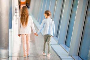 kleine entzückende Mädchen am Flughafen in der Nähe eines großen Fensters foto