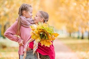 Kleine entzückende Mädchen im Freien am warmen, sonnigen Herbsttag foto