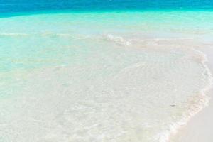 idyllischer tropischer strand mit weißem sand, türkisfarbenem ozeanwasser und schönem buntem himmel auf karibischer insel foto