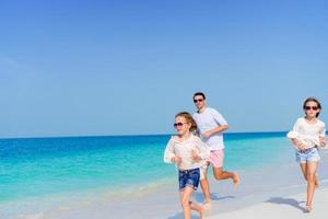 glückliche familie genießt die strandzeit und hat viel spaß am ufer foto