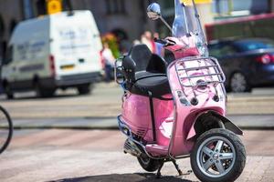 Rosafarbener Roller auf der Straße in der europäischen Stadt foto