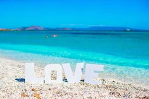 Wortliebe auf tropischem Strandhintergrund des türkisfarbenen Meeres und des blauen Himmels foto