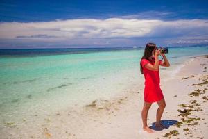 junge Frau fotografierte wunderschöne Meereslandschaft am tropischen Strand foto
