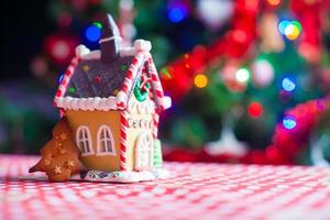 süßes Lebkuchenplätzchen und Süßigkeiten Ingwer Haus Hintergrund Weihnachtsbaum Lichter foto