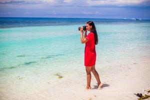 Profil der jungen Frau fotografiert schöne Meereslandschaft am weißen Sandstrand foto