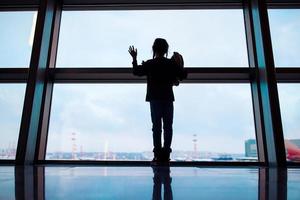 kleines kind im flughafen, das auf das einsteigen wartet foto