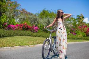 junge Frau, die auf einem tropischen Resort Fahrrad fährt foto