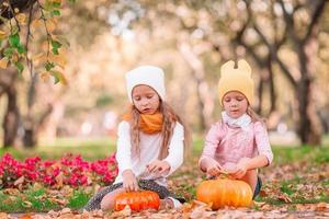 Kleine entzückende Mädchen mit Kürbis im Freien an einem warmen Herbsttag. foto