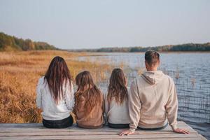 Schöne Familie am warmen Herbsttag in der Nähe des Sees foto