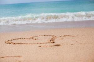 Herz im Sand an einem tropischen Strand gemalt foto