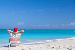 junger mann in weihnachtsmütze während des strandurlaubs foto