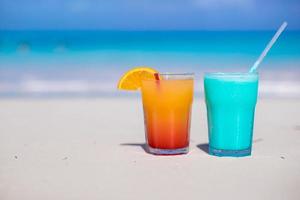 Nahaufnahme von Blue Curacao und Mango-Cocktail am weißen Sandstrand foto