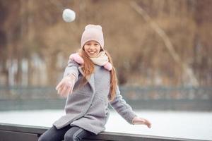 entzückendes kleines Mädchen, das auf der Eisbahn Schlittschuh läuft foto