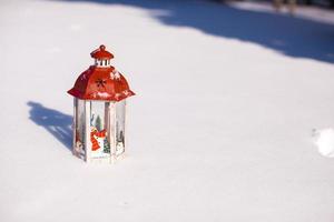 schöne rote Märchenlaterne auf weißem Schnee im Wald foto