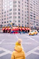 Entzückende kleine Mädchen haben Spaß auf dem Times Square in New York City foto