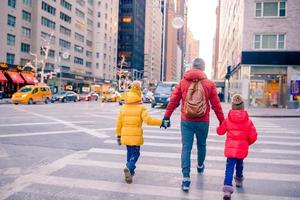 Familie von Vater und kleinen Kindern am Times Square während ihres Urlaubs in New York City foto