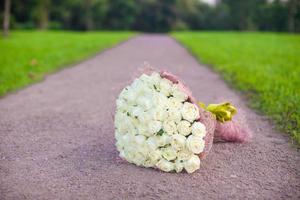 Unglaublich schöner großer Strauß weißer Rosen auf einem Sandweg im Garten foto