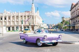 Blick auf eine Straße in der Altstadt von Havanna mit alten amerikanischen Oldtimern foto