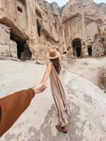glückliche junge frau auf dem hintergrund antiker höhlenformationen in kappadokien, türkei. Das Kloster ist eines der größten religiösen Gebäude. foto