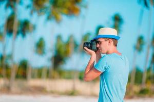 Profil des jungen Mannes fotografiert schöne Meereslandschaft am weißen Sandstrand foto