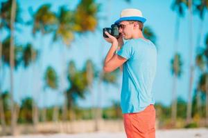 Profil des jungen Mannes fotografiert schöne Meereslandschaft am weißen Sandstrand foto