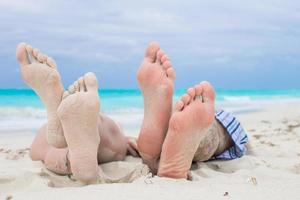 Nahaufnahme männlicher und weiblicher Füße auf weißem Sand foto