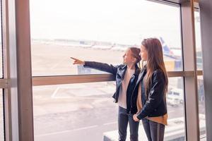 kleines kind im flughafen, das auf das einsteigen wartet foto