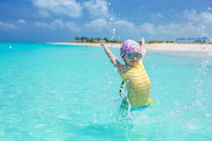 glückliches kleines mädchen hat spaß am strand während der sommerferien foto