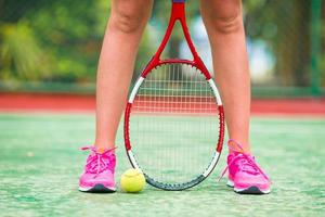 Nahaufnahme von Schuhen mit Tennisschläger und Ball im Freien auf dem Platz foto