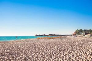 leerer Strand mit geschlossenen Sonnenschirmen am frühen Morgen an der portugiesischen Küste foto