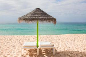 Strandliegen und Sonnenschirme im exotischen Resort an der Wüstenküste foto