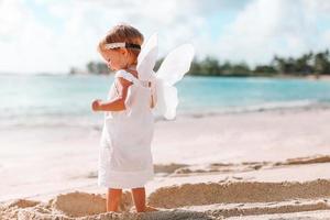 schönes junges Mädchen mit Engelsflügeln am Strand foto