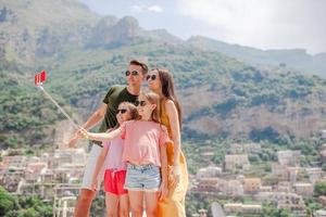 eltern und kinder, die selfie-fotohintergrund positano-stadt in italien an der amalfiküste machen foto