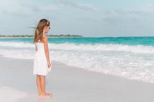 süßes kleines Mädchen am Strand während der Sommerferien foto