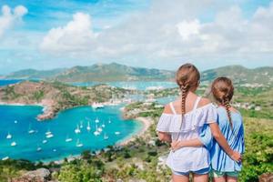 Entzückende kleine Kinder, die den Blick auf den malerischen englischen Hafen von Antigua in der Karibik genießen foto