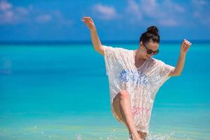 junge schöne Frau am Strand während der tropischen Ferien foto