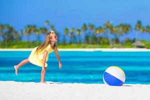 Kleines entzückendes Mädchen, das mit Luftball im Freien am Strand spielt foto