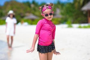entzückendes kleines Mädchen am Strand während der Sommerferien foto