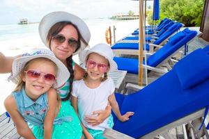 mutter und kleine mädchen, die selfie am tropischen strand machen foto