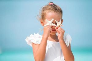 süßes kleines Mädchen am Strand während der Sommerferien foto