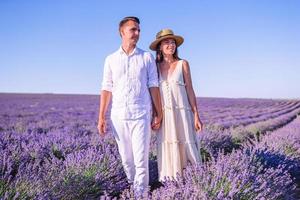 Familie im Lavendelblumenfeld bei Sonnenuntergang im weißen Kleid und im Hut foto