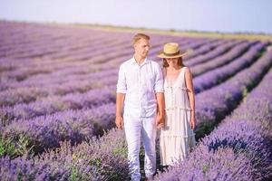 Familie im Lavendelblumenfeld bei Sonnenuntergang im weißen Kleid und im Hut foto