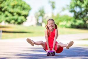 entzückendes kind, das skateboard im sommerpark fährt. foto