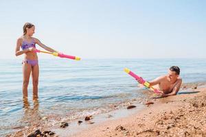 kleines mädchen und glücklicher vater, der spaß während des strandurlaubs hat foto